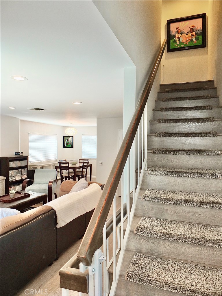 117 West Spring Street, Unit E Long Beach, CA 90806 - Photo 16 of 44 a view of staircase with lots of frames on wall and a dining table