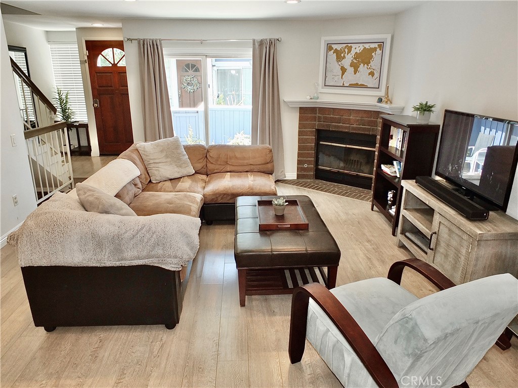 117 West Spring Street, Unit E Long Beach, CA 90806 - Photo 2 of 44 a living room with furniture a flat screen tv and a fireplace