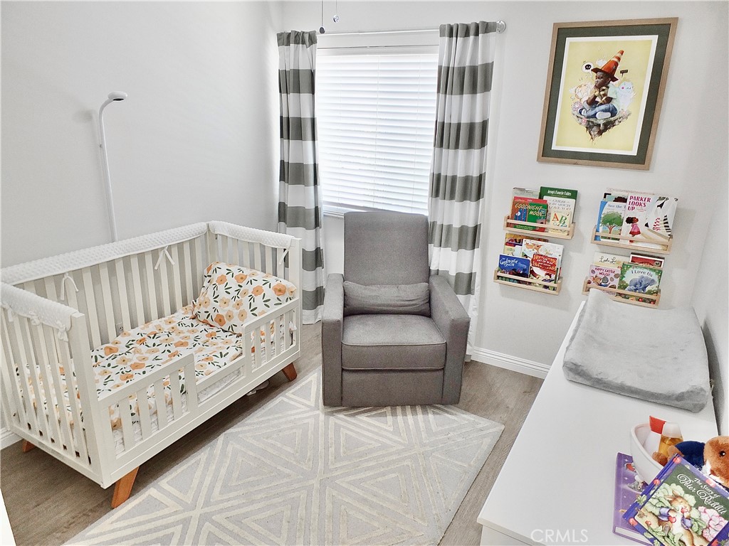 117 West Spring Street, Unit E Long Beach, CA 90806 - Photo 24 of 44 a bedroom with furniture and a white wooden floor