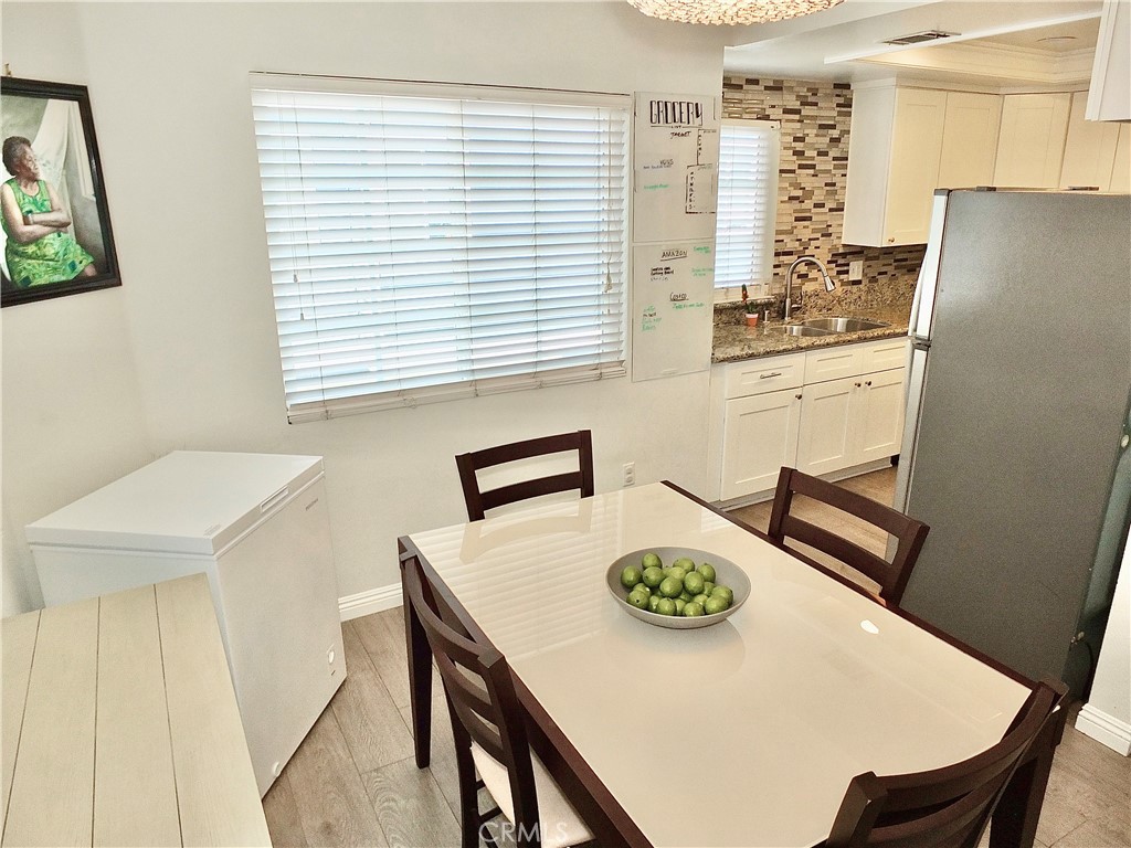 117 West Spring Street, Unit E Long Beach, CA 90806 - Photo 10 of 44 a kitchen with a table chairs and a refrigerator