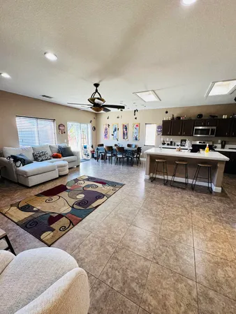 a living room with furniture and view of kitchen
