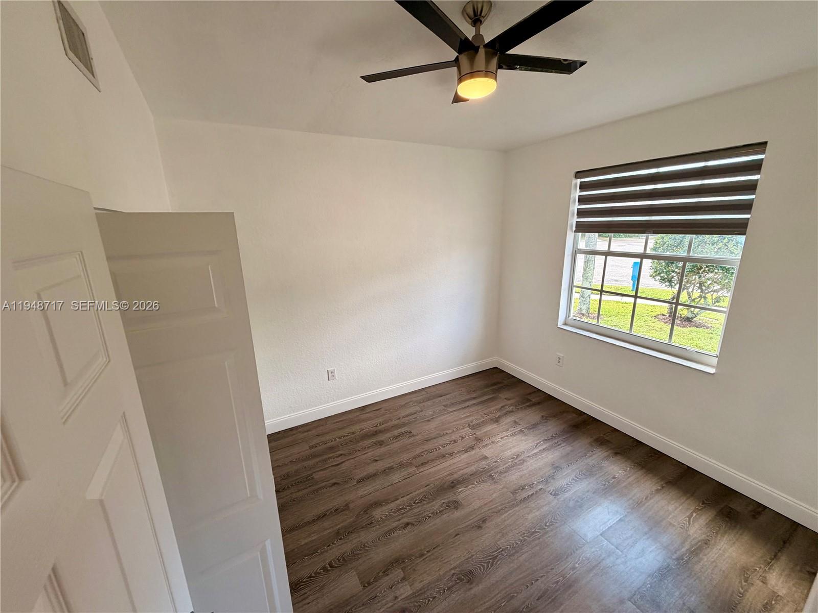 18709 Southwest 28th Street Miramar, FL 33029 - Photo 11 of 14 a view of an empty room with a window and a ceiling fan