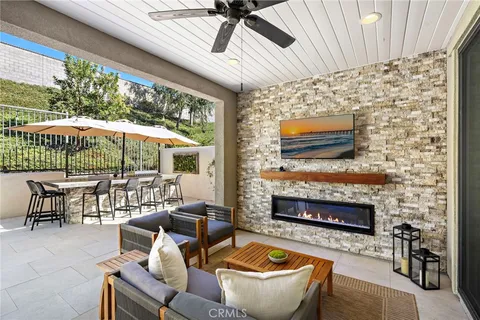 a outdoor space with patio fireplace couches and a fireplace with the potted plants