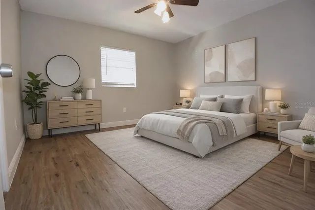 a bedroom with a bed cupboard mirror and window