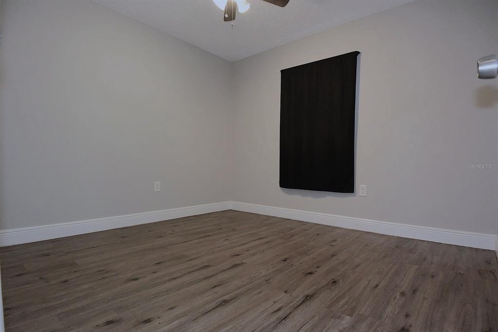 5845 Elm Street New Port Richey, FL 34652 - Photo 18 of 38 a view of an empty room with wooden floor and a window