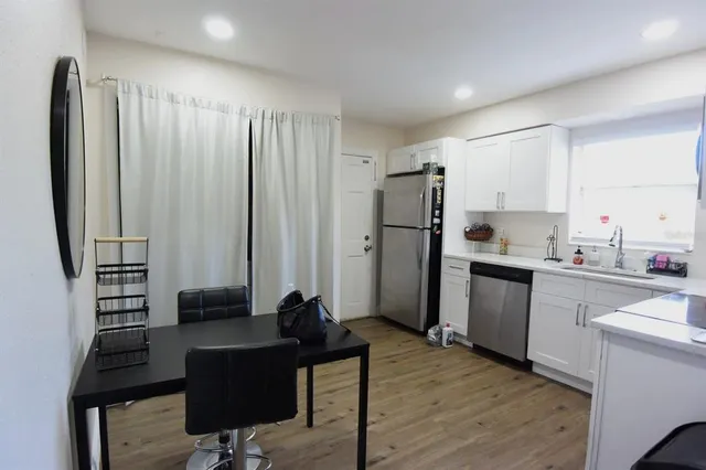 a kitchen with stainless steel appliances a refrigerator and wooden cabinets