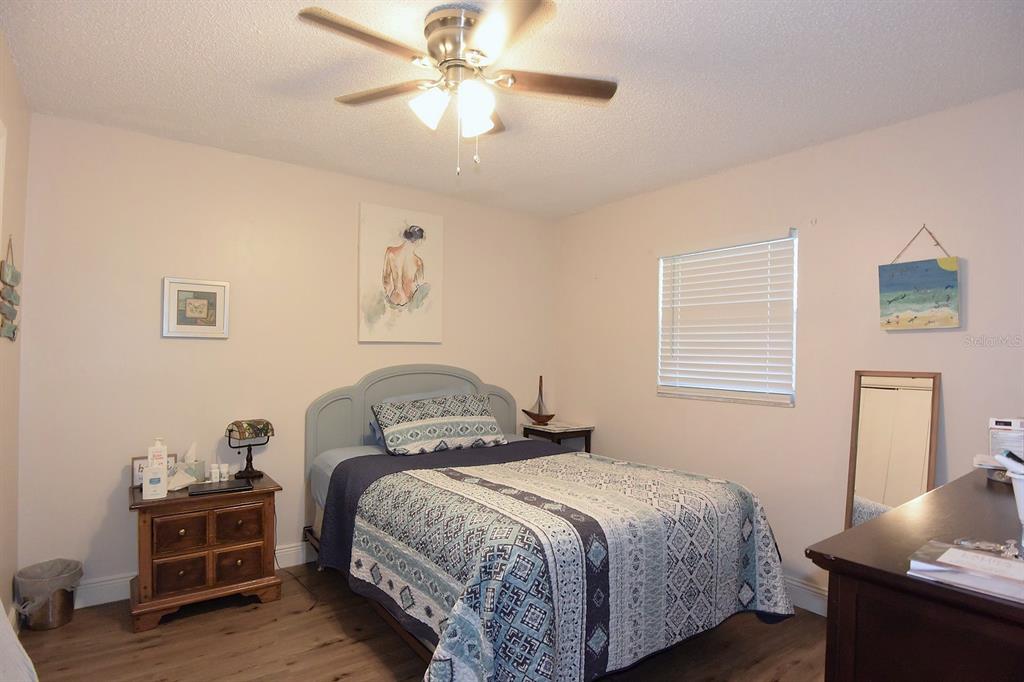 5845 Elm Street New Port Richey, FL 34652 - Photo 25 of 38 a bedroom with a bed and wooden floor