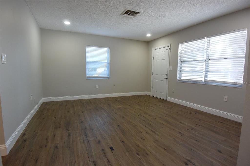 5845 Elm Street New Port Richey, FL 34652 - Photo 5 of 38 an empty room with wooden floor and windows