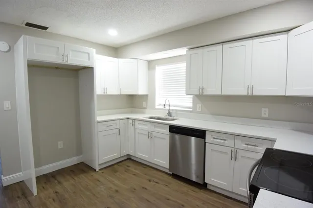a kitchen with granite countertop white cabinets and white appliances