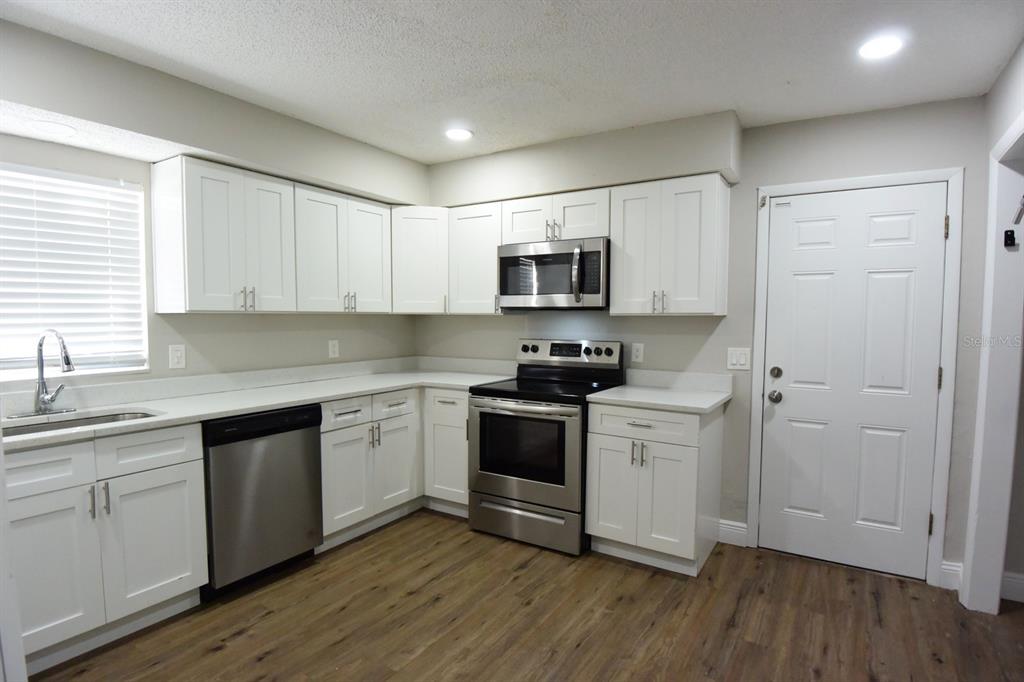 5845 Elm Street New Port Richey, FL 34652 - Photo 9 of 38 a kitchen with sink a microwave and cabinets