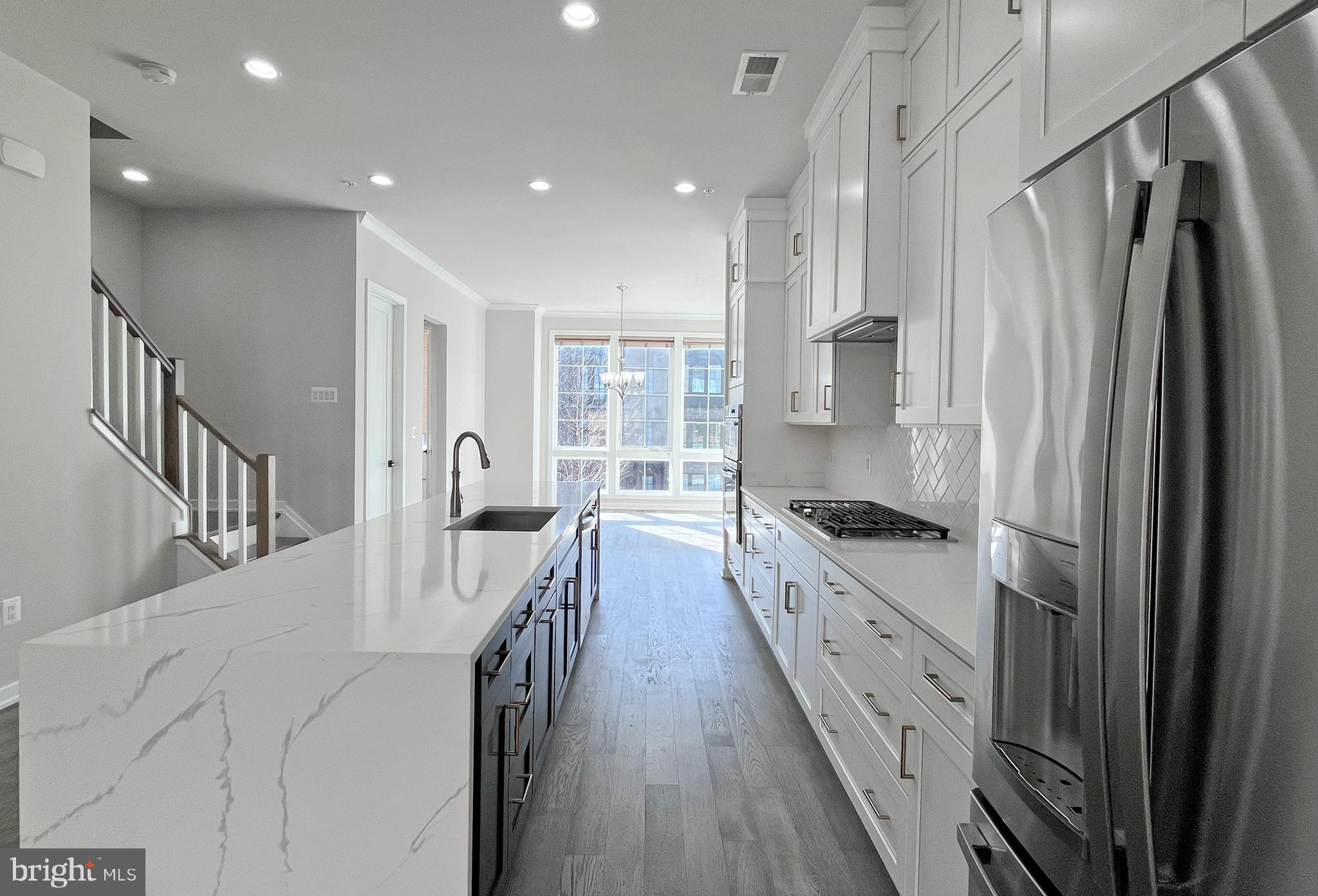 11714 Paysons Way Reston, VA 20191 - Photo 12 of 33 a kitchen with granite countertop a refrigerator a sink dishwasher a stove and a refrigerator with wooden floor