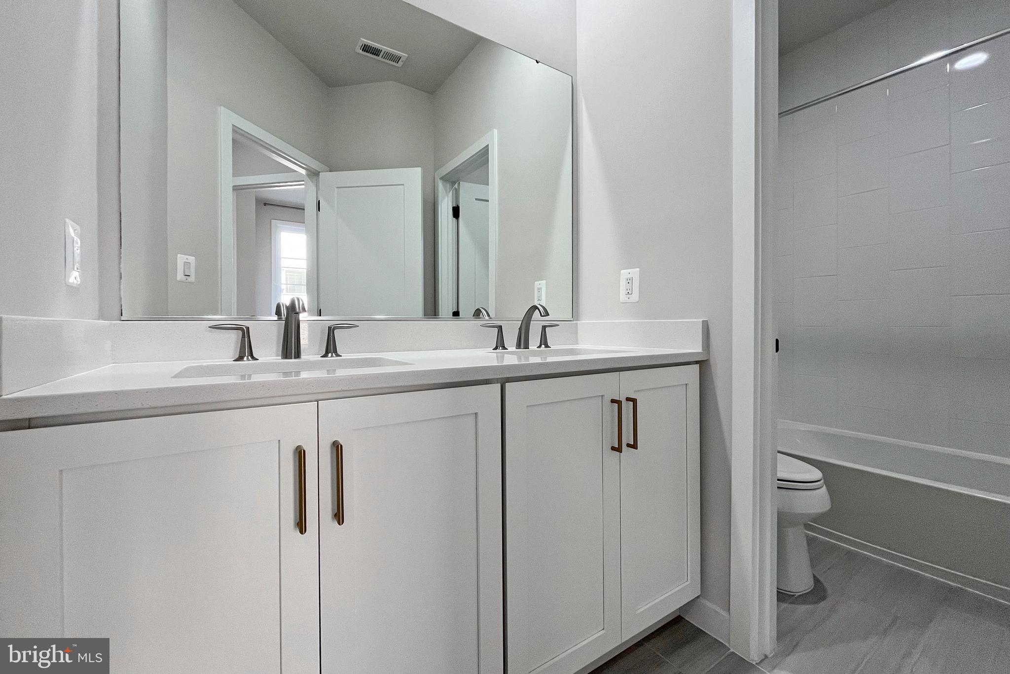 11714 Paysons Way Reston, VA 20191 - Photo 19 of 33 a bathroom with a double vanity sink toilet and a mirror