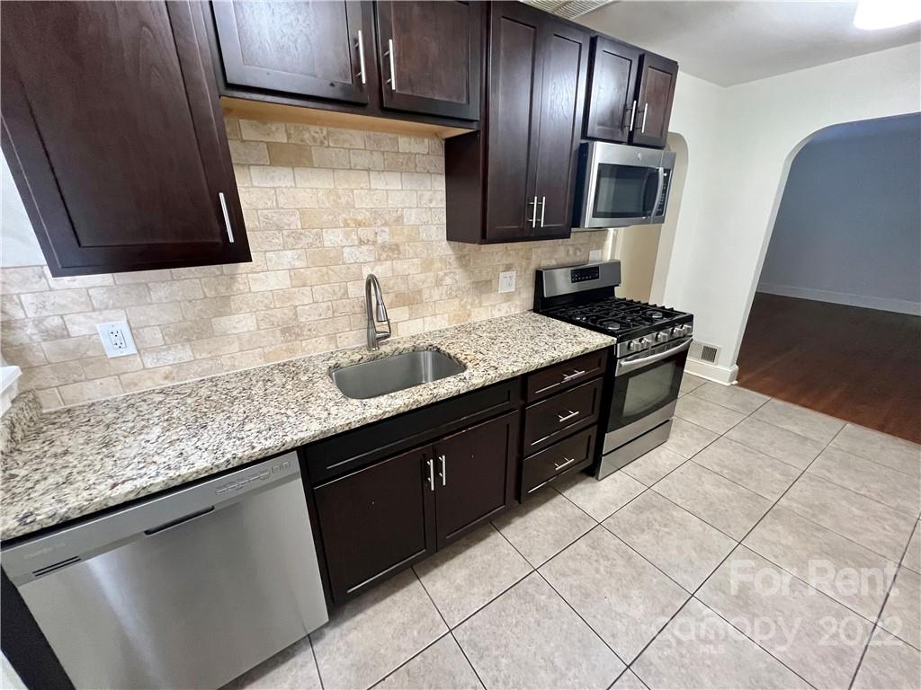 1708 Dilworth Road West, Unit 2 Charlotte, NC 28203 - Photo 5 of 8 a kitchen with stainless steel appliances granite countertop a sink stove and refrigerator