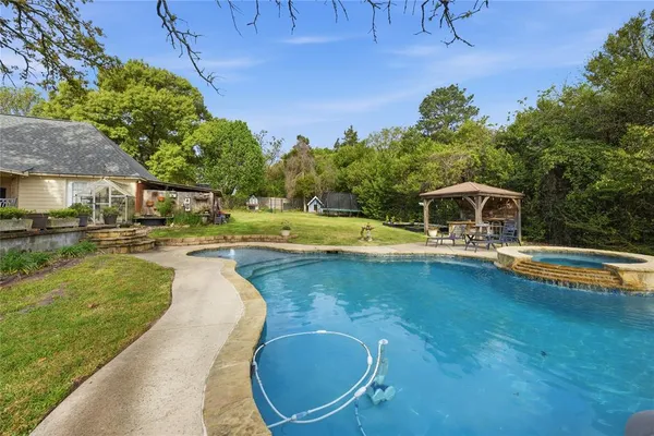 a view of a house with a big yard and large trees