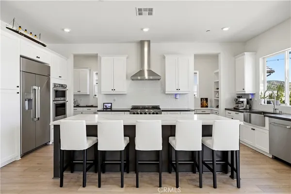 a kitchen with kitchen island stainless steel appliances a sink stove and refrigerator