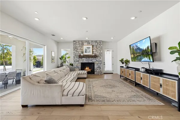 a kitchen with stainless steel appliances a dining table chairs refrigerator and sink