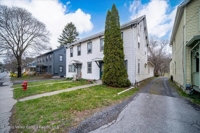 a view of a house with a yard and pathway