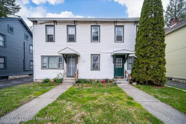 a front view of a house with a garden and yard
