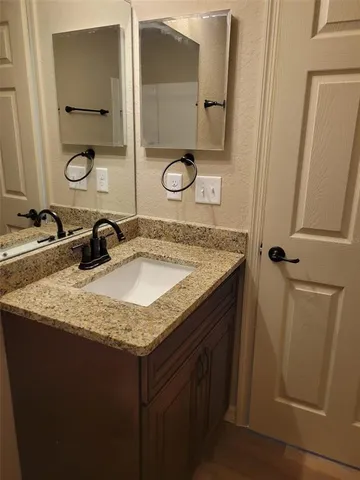 a bathroom with a granite countertop sink and a mirror