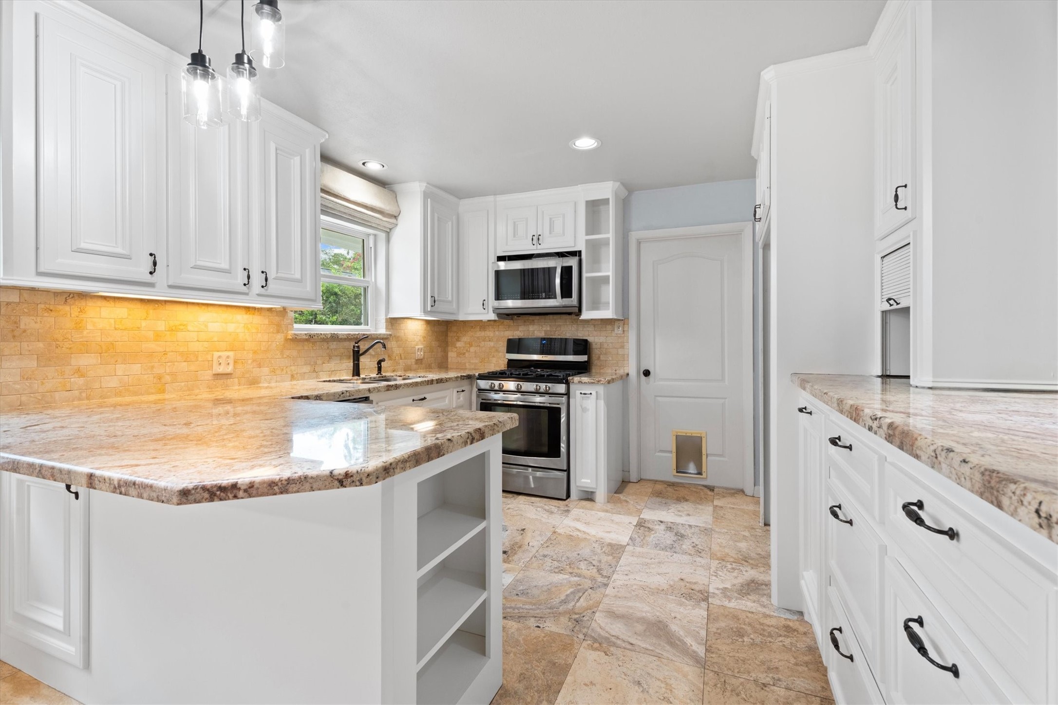 1328 Bingle Road Houston, TX 77055 - Photo 15 of 48 The kitchen features freshly painted cabinets, granite counter tops, travertine flooring and backsplash, stainless steel appliances and under cabinet lighting.