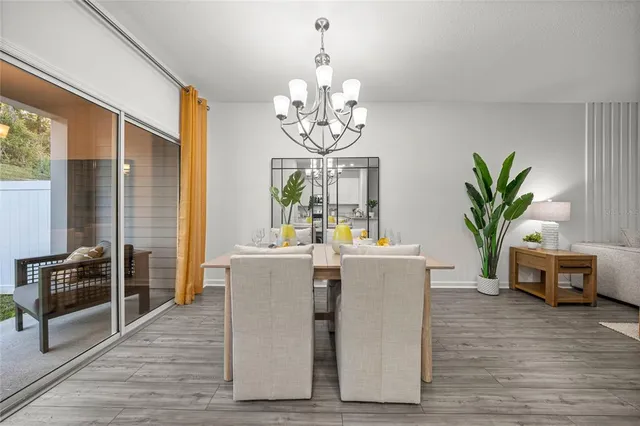 a living room with furniture a potted plant and a chandelier