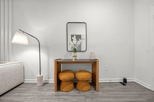 a view of a livingroom with wooden floor and a mirror
