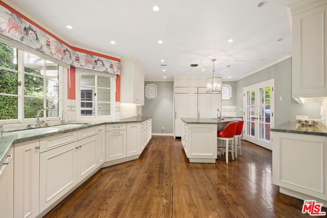 524 North Rockingham Avenue Los Angeles, CA 90049 - Photo 11 of 24 a kitchen with a sink microwave and wooden floor