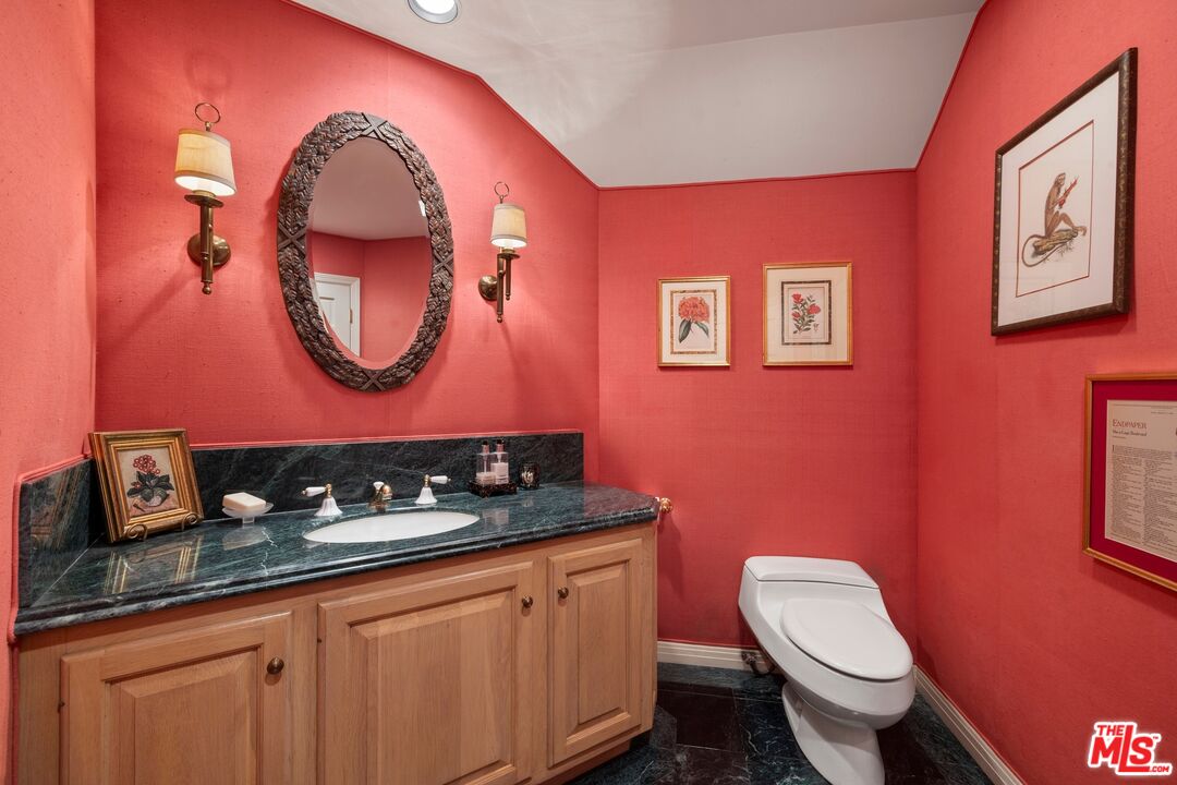524 North Rockingham Avenue Los Angeles, CA 90049 - Photo 13 of 24 a bathroom with a toilet a sink and a mirror