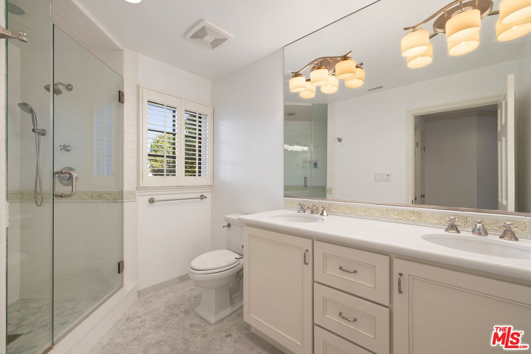 524 North Rockingham Avenue Los Angeles, CA 90049 - Photo 19 of 24 a spacious bathroom with a granite countertop sink a toilet and a mirror