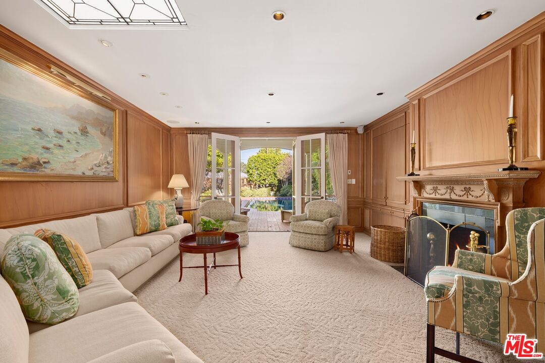 524 North Rockingham Avenue Los Angeles, CA 90049 - Photo 7 of 24 a living room with furniture a fireplace and a large window