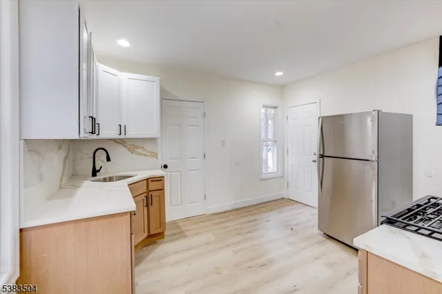 a kitchen with stainless steel appliances granite countertop a refrigerator a stove and a sink