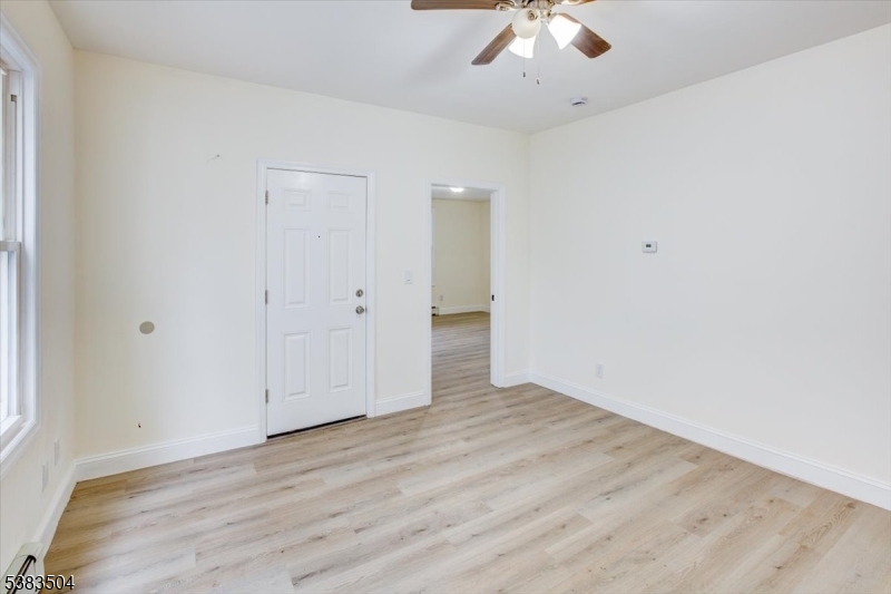 546 Morris Street, Unit 1 Orange, NJ 07050 - Photo 5 of 17 an empty room with a ceiling fan and wooden floor