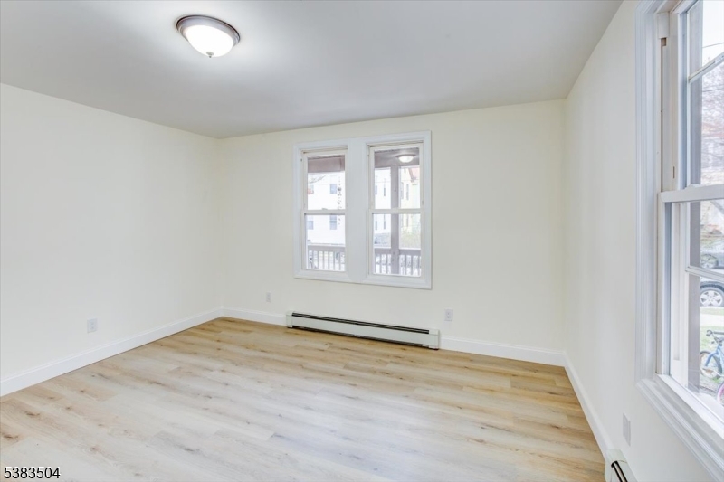 546 Morris Street, Unit 1 Orange, NJ 07050 - Photo 6 of 17 an empty room with wooden floor and windows