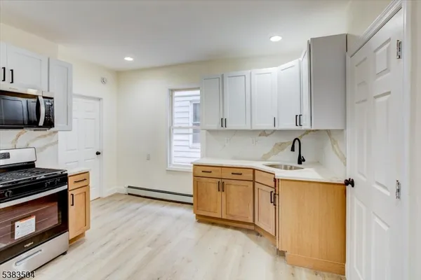 a kitchen with stainless steel appliances a stove a sink and a refrigerator