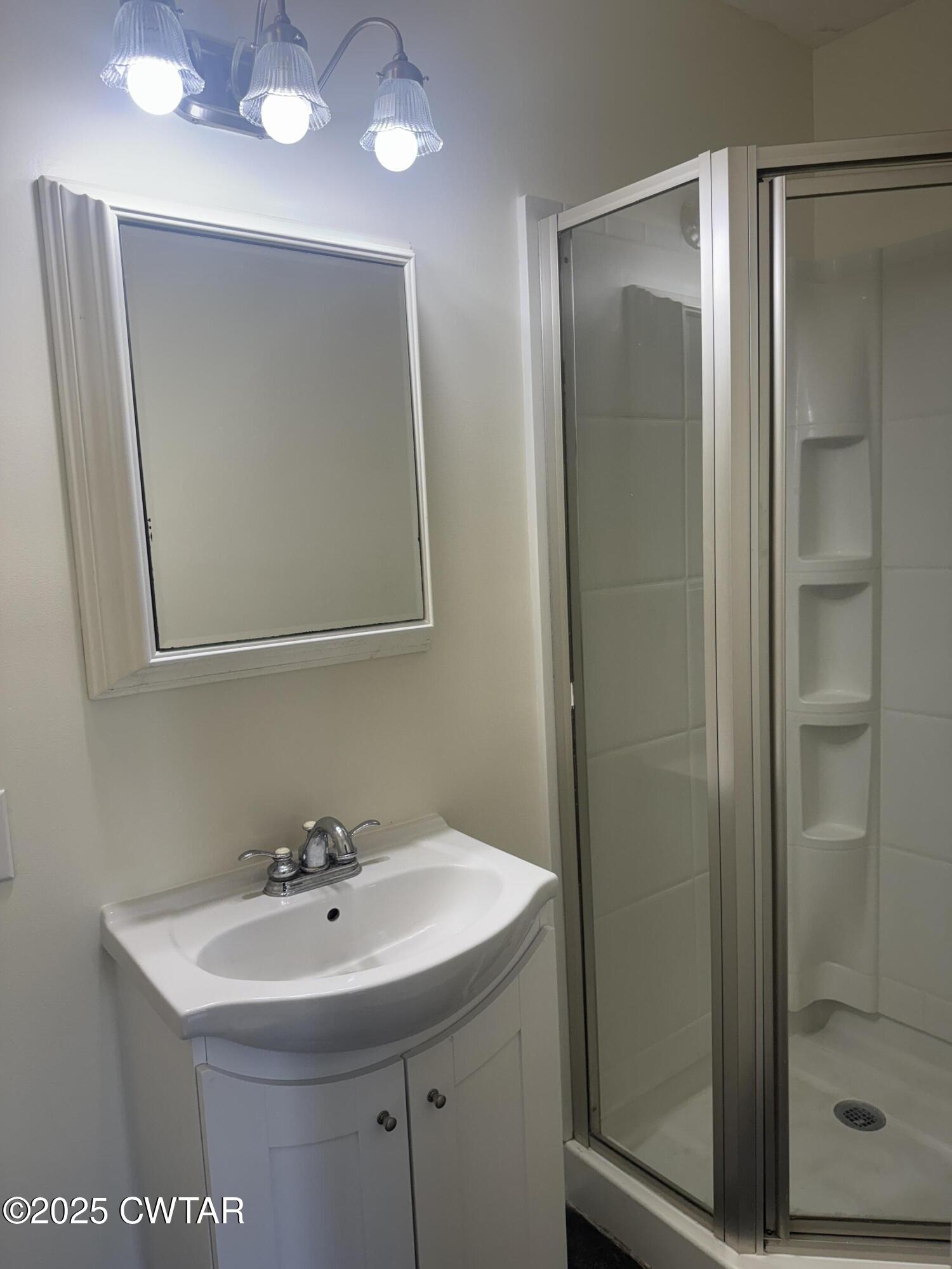 511 White Avenue Henderson, TN 38340 - Photo 18 of 28 a bathroom with a sink a mirror and shower