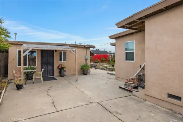a view of a patio with table and chairs and potted plants