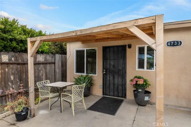 a view of a patio with table and chairs potted plants