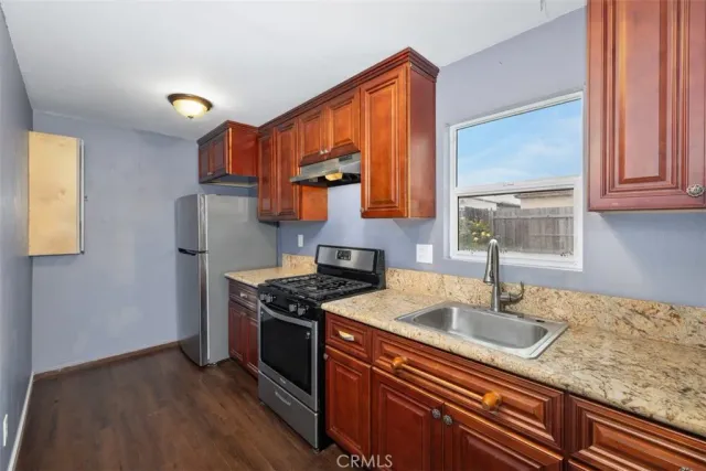 a kitchen with stainless steel appliances granite countertop a sink stove and cabinets