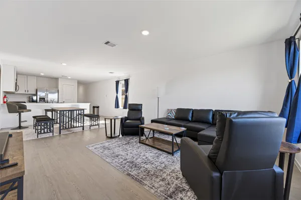 a living room with furniture and view of kitchen
