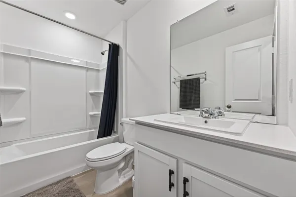 a bathroom with a sink a toilet a mirror and shower