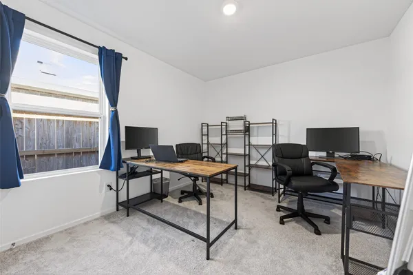 a view of a workspace with furniture and a window
