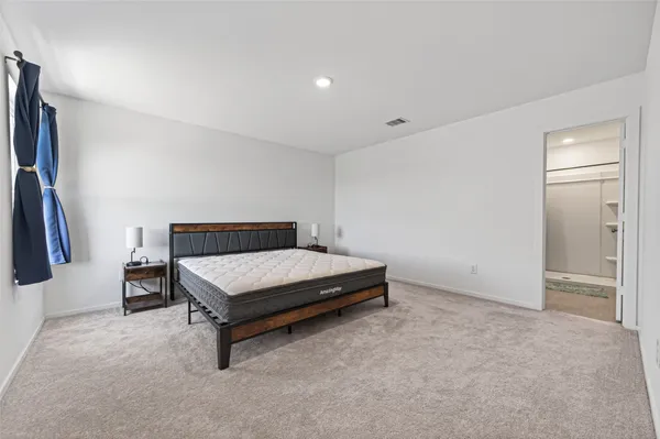 a bedroom with a bed and a flat tv screen on the wall