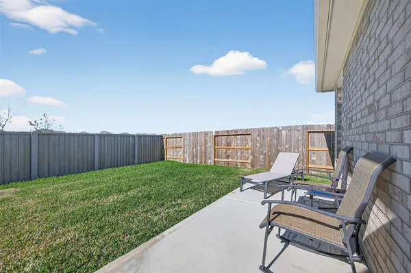 a view of a lounge chairs in back yard of the house