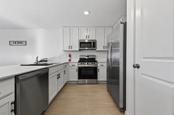 a kitchen with a refrigerator and a stove top oven