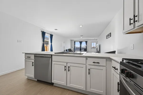 a kitchen with white cabinets and appliances