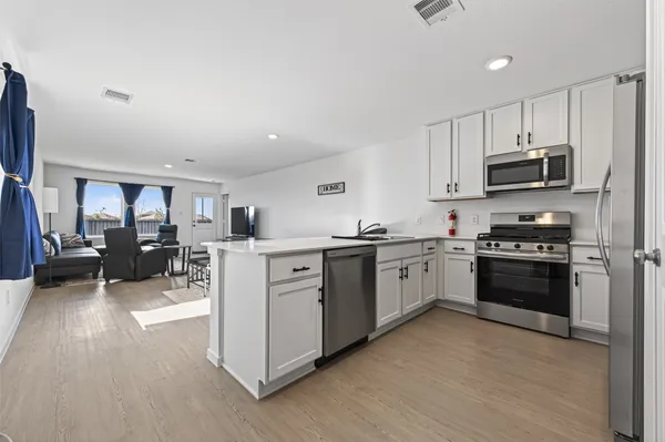 a kitchen with stainless steel appliances and white cabinets