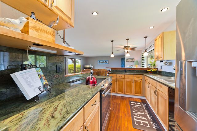 a very nice looking open kitchen with stainless steel appliances granite countertop a sink and cabinets