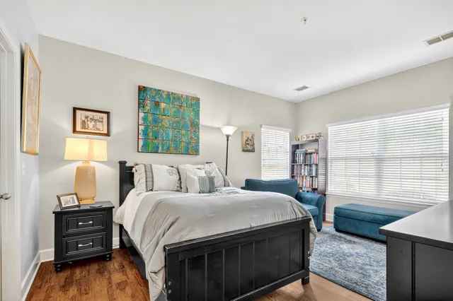a bedroom with a bed and a dresser next to a window