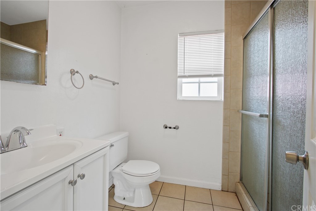 3655 Webster Avenue Long Beach, CA 90810 - Photo 14 of 22 a bathroom with a toilet sink vanity and mirror