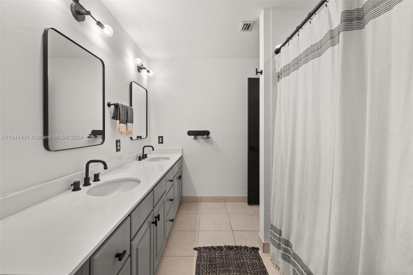 2001 Biscayne Boulevard, Unit 2409 Miami, FL 33137 - Photo 12 of 29 a bathroom with a double vanity sink a mirror and a shower